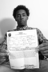 Georgia State student, Justin Avery, holds in his hand the police report that details the events of his arrest. 