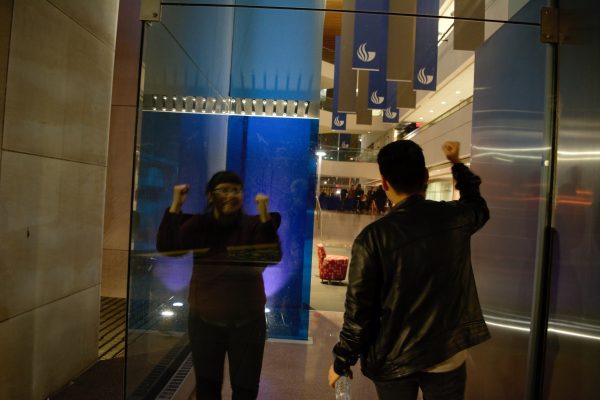 Protesters bang on the glass of the Honors College and chant rhythmically. Photo by Sean Keenan | The Signal