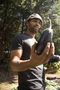 Nuri Icgoren holds one of the eggplants grown on his urban farm.  Photo by Jade Johnson | The Signal 