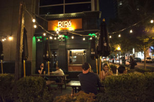 Patrons enjoy drinks in front of Rí Rá Irish Pub located off Crescent Avenue in Midtown Atlanta. Photo by Jade Johnson | The Signal 